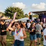 Attendees with pulseras de tela con chip personalizadas enjoying a vibrant festival atmosphere, showcasing live music and community.
